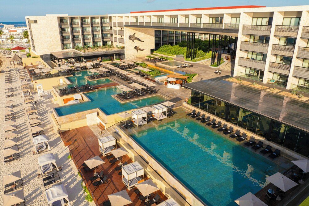 Piscina exterior con cabañas en Devossion Playa del Carmen