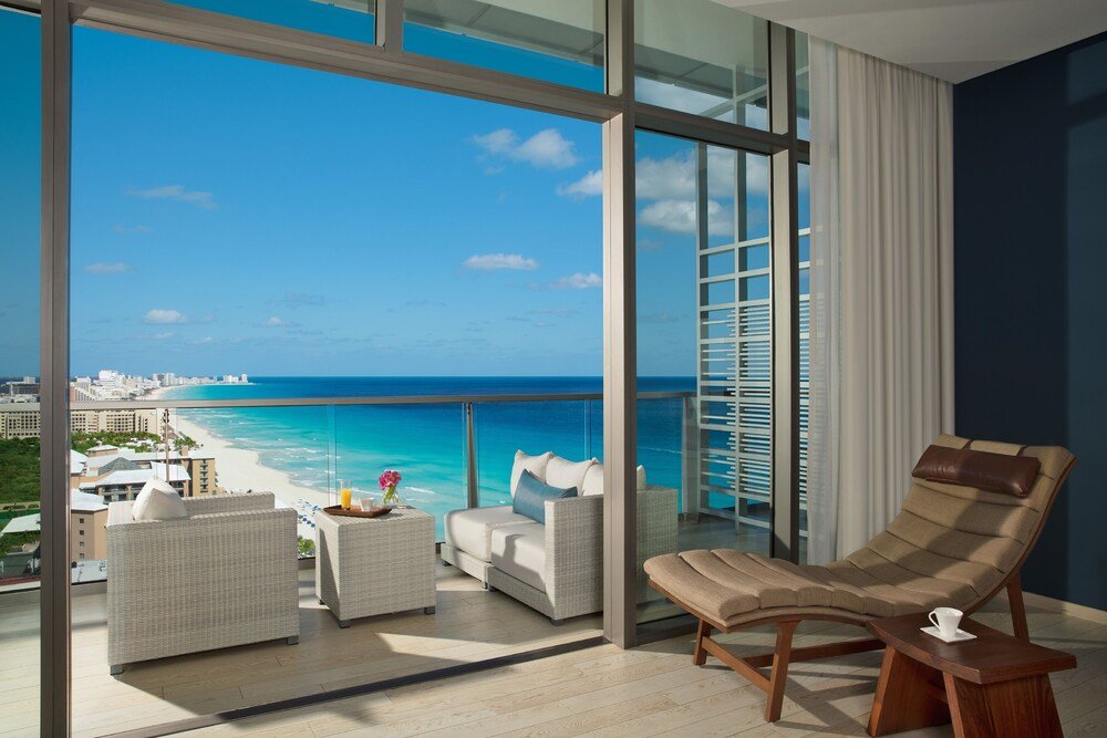 Outdoor pool and sun loungers at Secrets The Vine Cancun resort